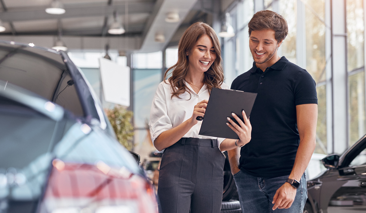 Mitarbeiterin und Kunde schauen auf ein Blatt Papier auf einem Klemmbrett.