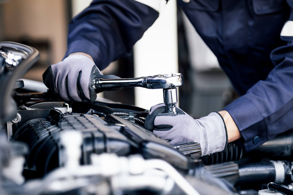 Mitarbeiter arbeitet am PKW Motorraum