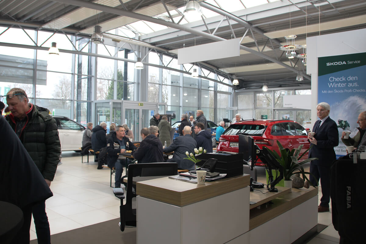 Wildgrillenevent im Autohaus. Mehrere Personen im Autohaus